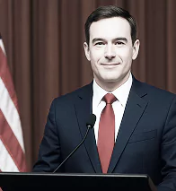 A man in a suit and tie stands confidently at a podium