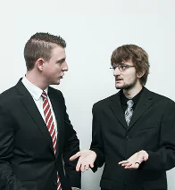 Two men standing together, engaged in conversation