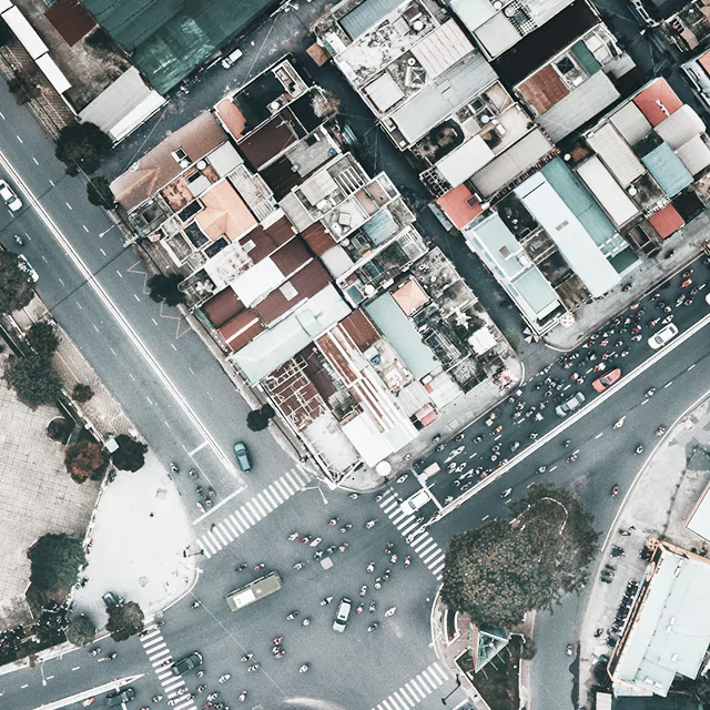Aerial view of a bustling city street filled with cars and pedestrians