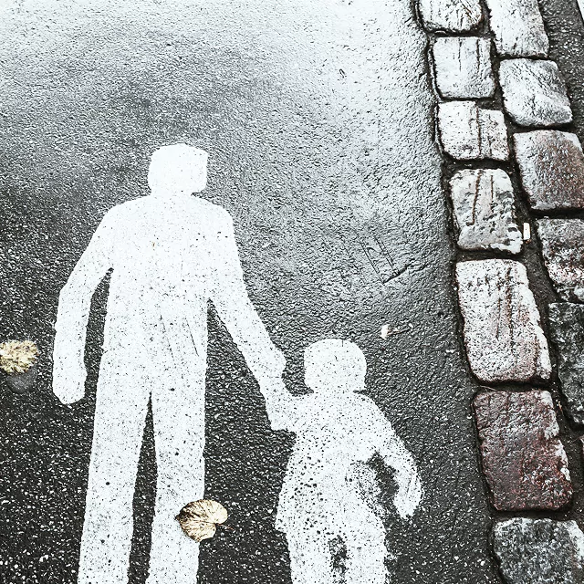 Paint of a man and a child walking together on a sidewalk