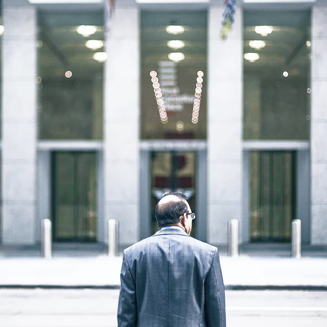 A man in a suit and tie confidently walks down a city street