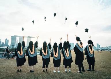 A group of graduates joyfully throwing their caps into the air