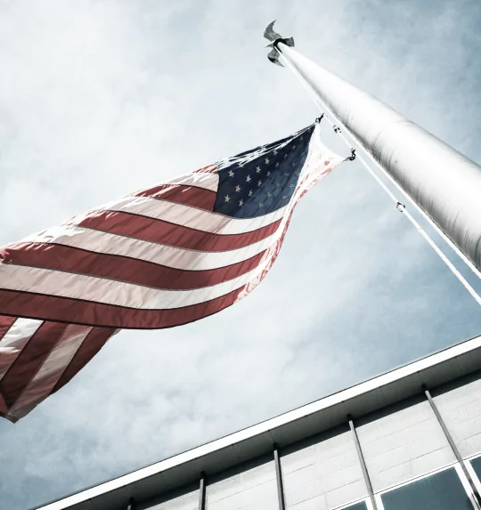 An American flag waves proudly in front of a building
