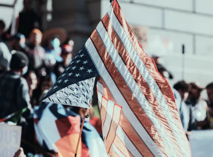 A large crowd of people proudly holding an American flag